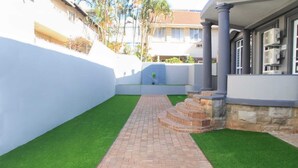 A paved pathway leading to a building entrance with a stone staircase. - The Cato Suites Hotel (Durban)