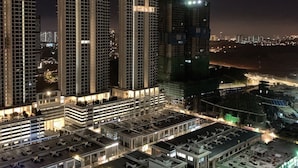 A nighttime view of a high-rise building complex with multiple floors and a rooftop area.
