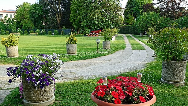 A garden pathway with potted plants and a bench. - Nice studio only 15Km  from Venice (Mira)
