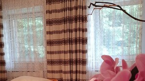 A room with a bed, a wooden table, and a window with curtains. - Haus Barnabas im Engel - Gasthaus Engel (Utzenfeld)