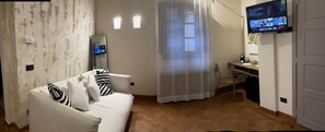Suite estudio familiar | Área de sala de estar | Televisión de pantalla plana