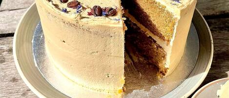 Ein runder Kuchen mit fehlendem Stück, auf einem Teller auf einem Holztisch.