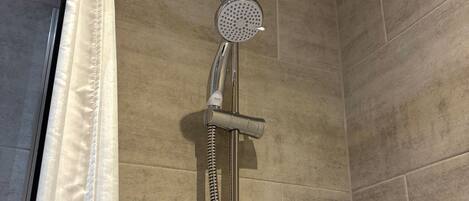Een douche met een handdouche en een slang.