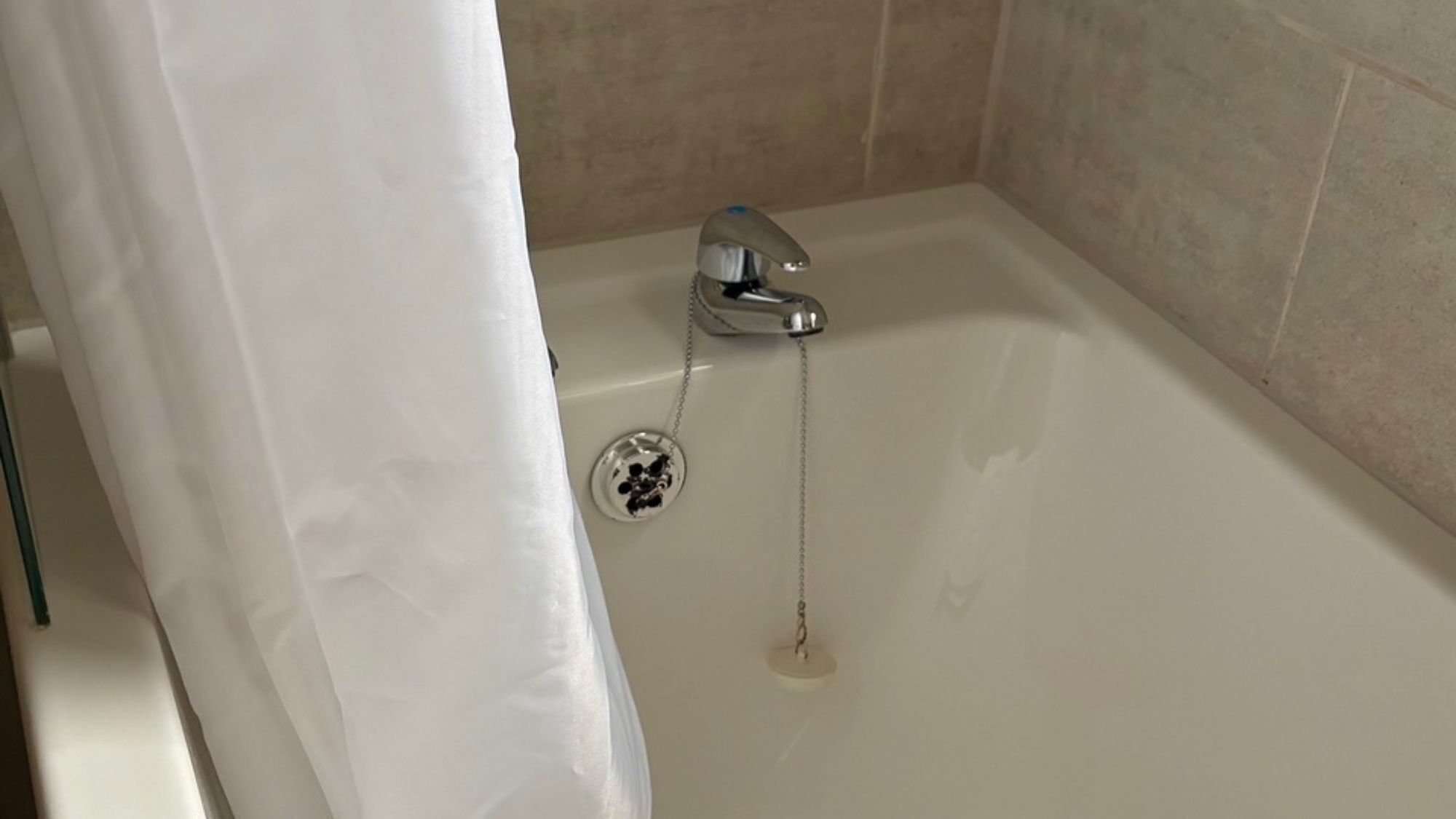 Et badekar med armatur og prop.