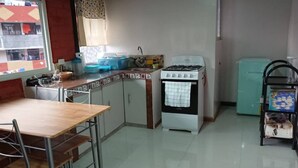 A compact kitchen with a gas stove, a sink, and a small refrigerator. - El Aguacate (Baños de Agua Santa)