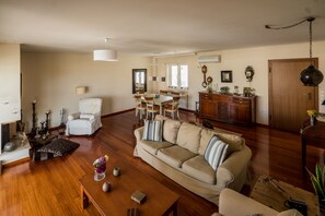 A spacious living room with a sofa, a dining table, and a kitchen area.