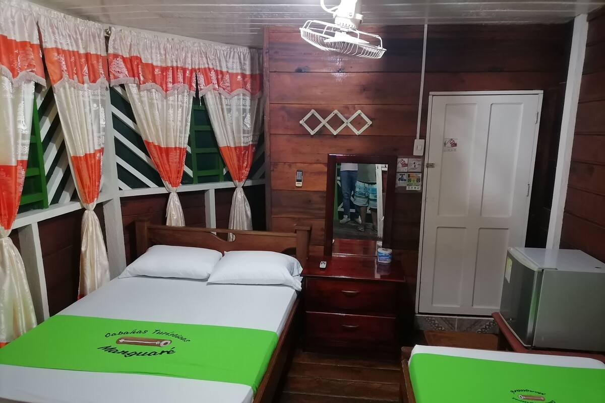 Une chambre avec un lit, une commode, un miroir et un téléviseur.