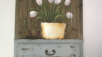 A rustic wall art of a flower pot with tulips.