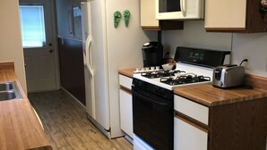 Eine Küche mit Herd, Mikrowelle, Kühlschrank und Holzarbeitsplatten.