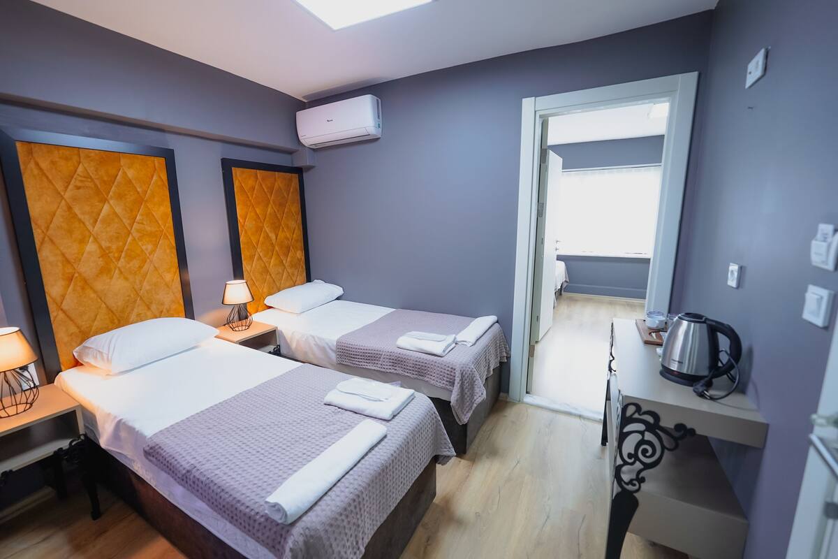 Een hotelkamer met twee bedden, een kitchenette en uitzicht.