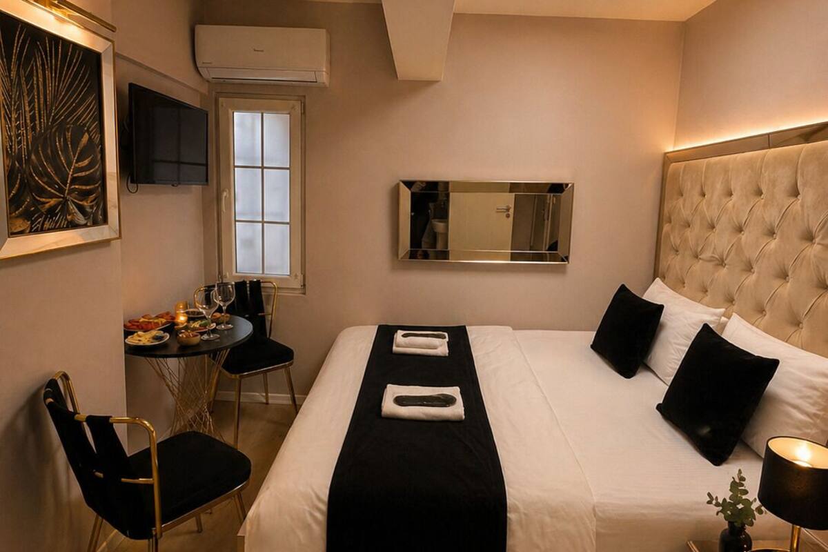 Een hotelkamer met een bed, nachtkastje, stoel, bureau en een televisie.
