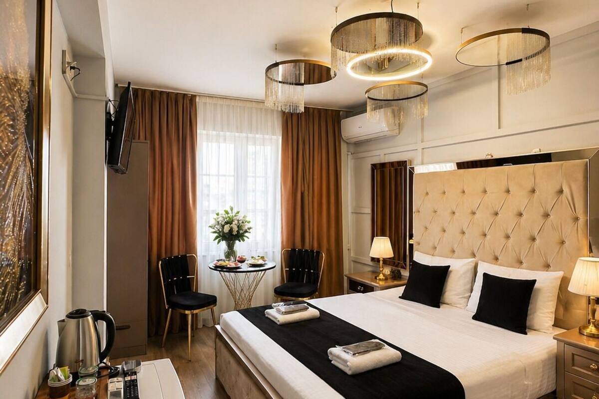 Hotelkamer met een groot bed, nachtkastjes, een bureau, een stoel, een televisie en een raam met gordijnen.