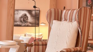 A striped armchair with a knitted pillow, a black floor lamp, and a framed picture on the wall. - A PERFECT TREASURE -  KNIGHTSBRIDGE LUXURY MEWS APARTMENT (London)