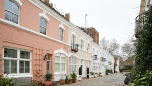 A cobblestone street lined with pastel-colored buildings, potted plants, and a bench. - A PERFECT TREASURE -  KNIGHTSBRIDGE LUXURY MEWS APARTMENT (London)