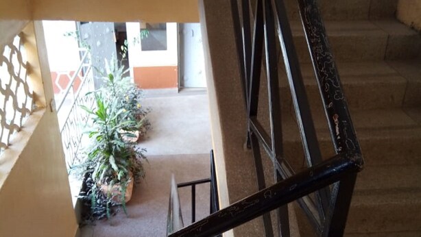 A staircase with a metal railing, leading to an outdoor area with potted plants. - Silverstone Park Bar & Guest House (Nairobi)