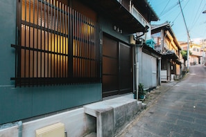 Um edifício tradicional japonês com portas deslizantes e uma rua estreita.