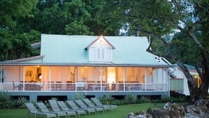 A two-story building with a balcony and outdoor seating area. - Beachcliff Villa Negril (Negril)