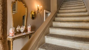 A grand staircase with a marble finish, a large ornate mirror, and wall sconces. - Live the high life in Lake Como in a period villa with lake view & private pool (Menaggio)