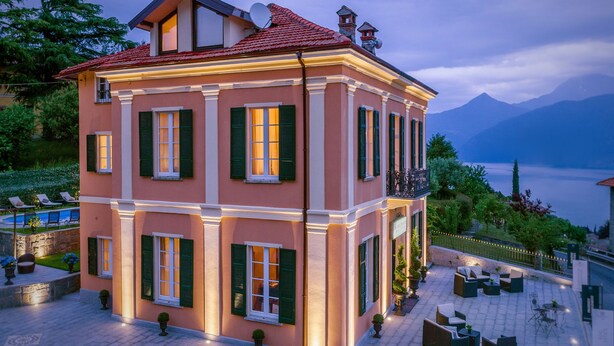 A two-story building with a red-tiled roof, green shutters, and a balcony with outdoor seating. - Live the high life in Lake Como in a period villa with lake view & private pool (Menaggio)