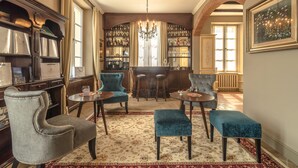 A bar area with a chandelier, bar stools, and a wine rack. - Live the high life in Lake Como in a period villa with lake view & private pool (Menaggio)