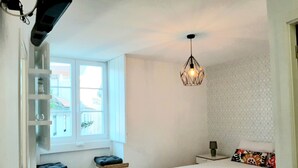 Una camera da letto con un letto, un comodino, una lampada, una finestra e scaffali a muro.
