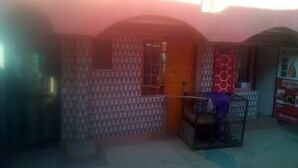 A courtyard with a small seating area, a vending machine, and a door leading to an interior space. - Tripple Arrow Guest House (Nairobi)