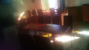 A dining area with tables and chairs, a window with blinds, and a 'No Smoking' sign on the wall. - Tripple Arrow Guest House (Nairobi)