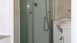 A glass-enclosed shower stall with a toilet and sink in a bathroom. - Independent studio in a quiet building with small patio (Vernet-les-Bains)