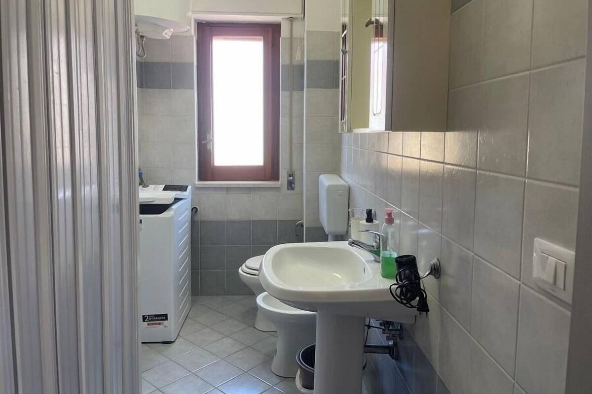 Un baño pequeño con inodoro, lavamanos y lavadora.