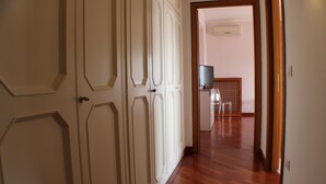 A hallway with wooden flooring and white doors with decorative moldings. - Orchidea (Tropea)
