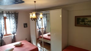 A bedroom with a bed, a wardrobe, a chandelier, and a painting on the wall. - Sabbia (Tropea)
