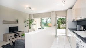 A modern apartment with a living area, kitchen, and balcony.