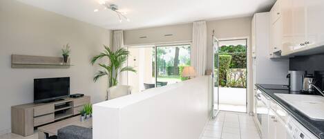 A modern apartment with a living area, kitchen, and balcony.