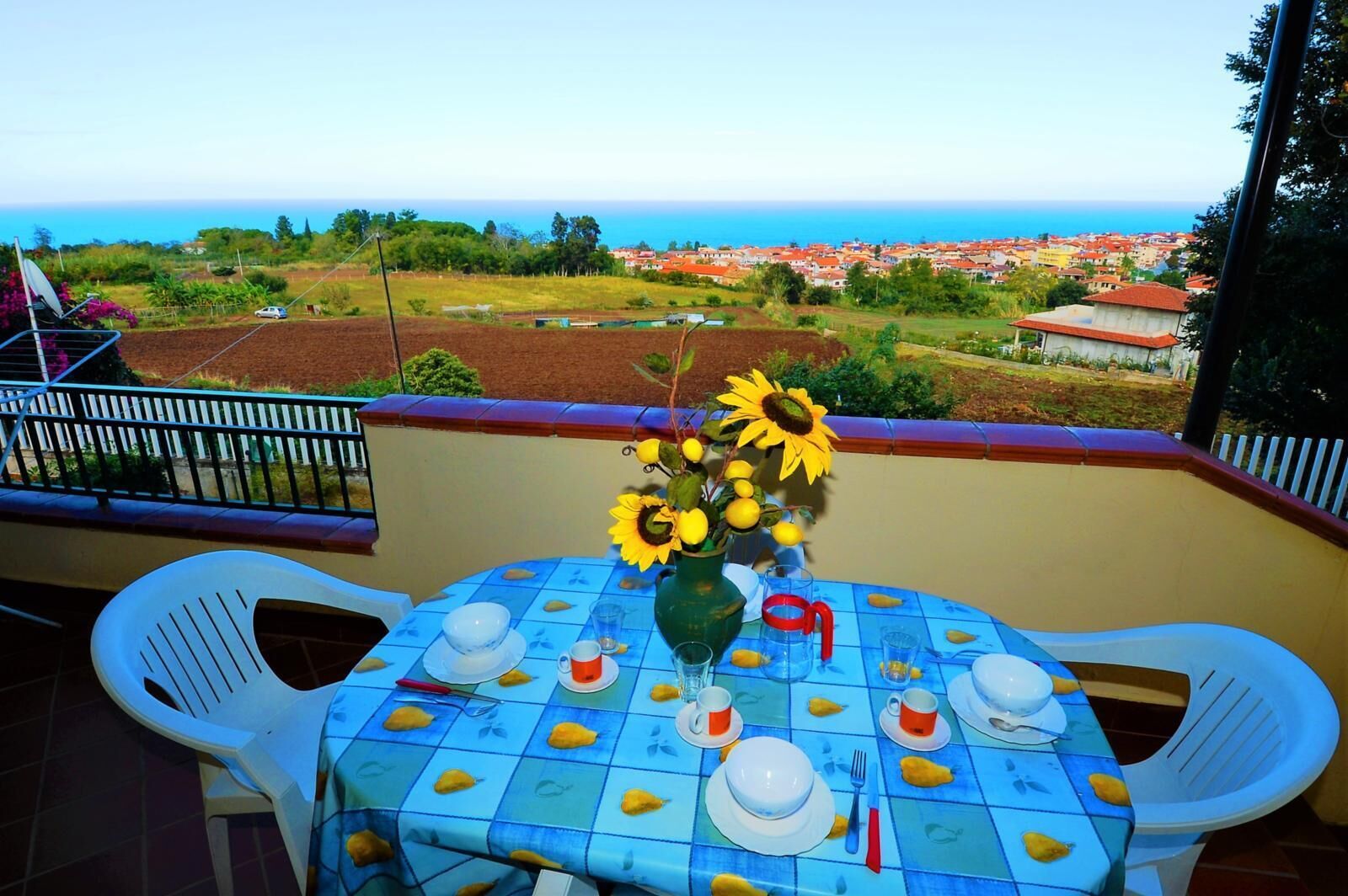 Une table dressée pour deux personnes, avec vue sur une ville côtière.