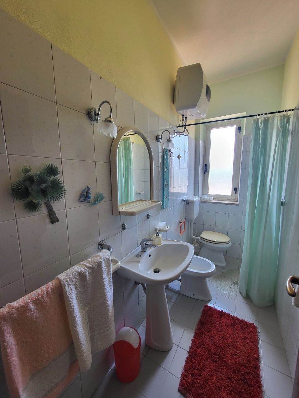 A bathroom with a sink, toilet, and shower area.