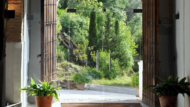 An arched doorway leading to a lush garden with potted plants on either side. - Los Pozos de  la Nieve Apartment Luna Rural Apartments, province of Sevilla (Constantina,)