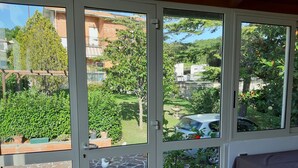 A room with a view of a garden, a stone patio, and a covered seating area. - Vacation House Rita in green Umbria (Gubbio)