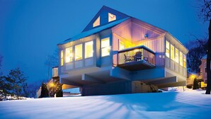 A two-story house with a balcony, surrounded by snow. - Christmas Mountain Village Resort fully stocked w/ 13 ski hills, 27 hole golf, tennis courts & more (Wisconsin Dells)