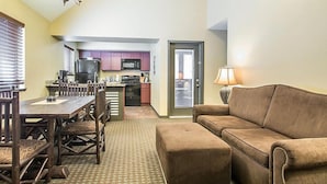 A compact living space with a dining area, kitchenette, and a sofa.