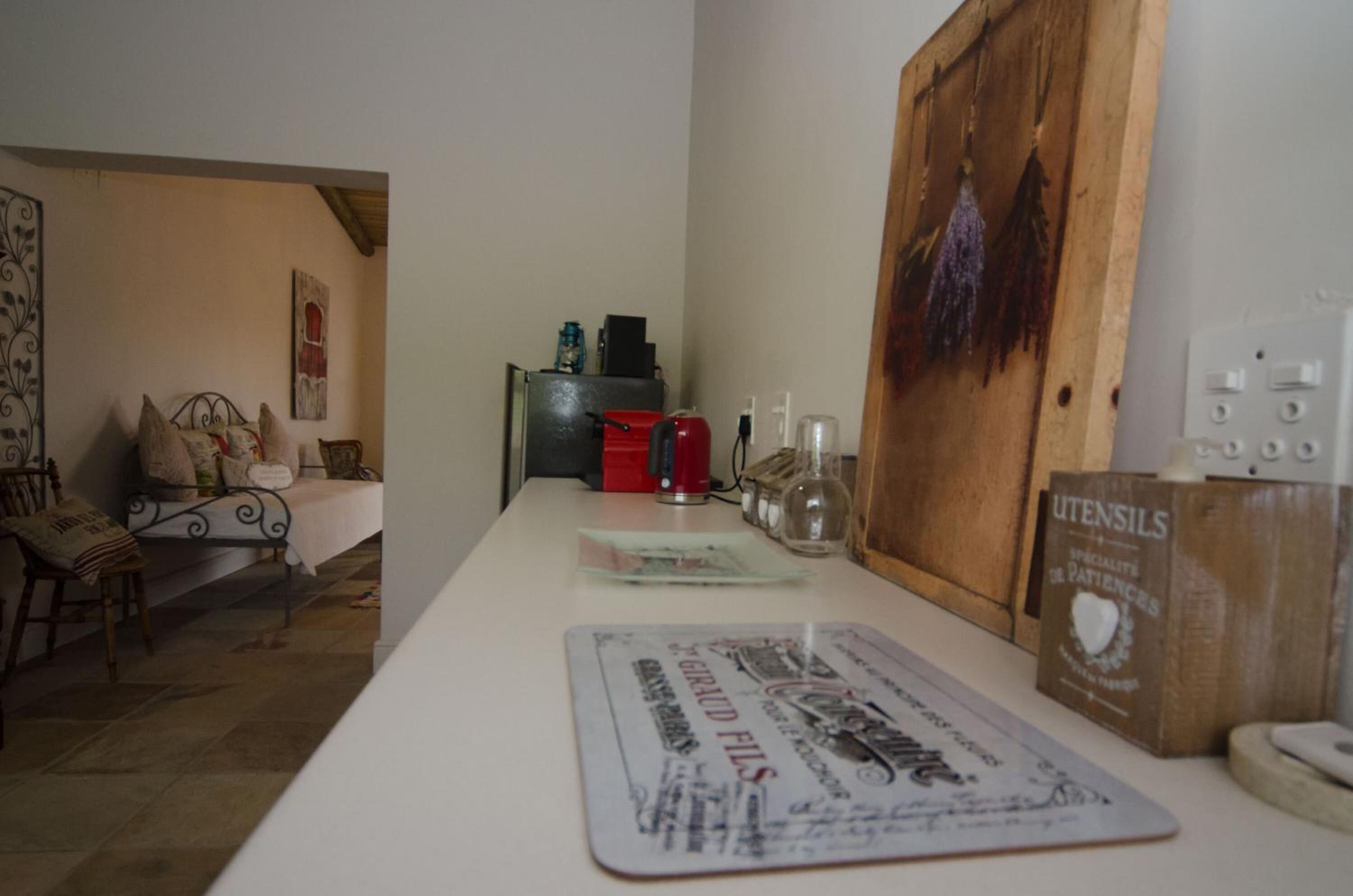 Une pièce comprenant un lit, une table avec un set de table, une boîte à outils rouge et un meuble en bois avec une pancarte.