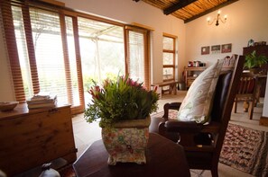 A cozy living room with a wooden chair, a wooden table, and a potted plant.