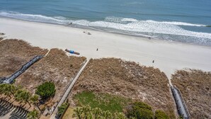 A beach with a boardwalk and dunes.