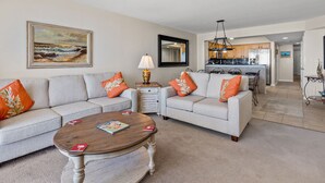 A living room with a sofa set, coffee table, and a painting on the wall.
