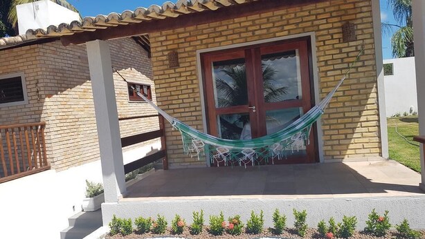 A brick house with a porch, a hammock, and a door. - Lagoa View (Tibau do Sul)