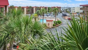 A residential area with multiple apartment buildings, a swimming pool, and a small parking area. - Best panoramic views in NMB! Views of inlet, across street from beach, pool, tennis, fish, surf (North Myrtle Beach)