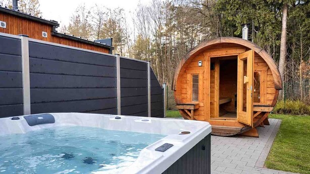 A hot tub and a wooden sauna in a backyard.