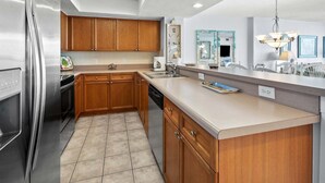Una cocina moderna con armarios de madera, electrodomésticos de acero inoxidable y una isla grande con un lavamanos.
