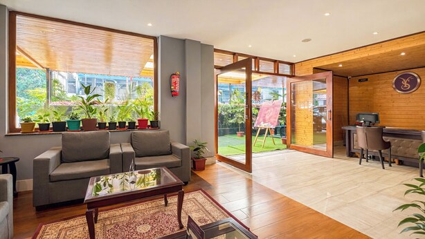 A modern living room with a sofa, coffee table, and potted plants. - Sumitel Shangrila (Gangtok)
