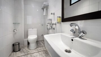 A modern bathroom with a toilet, bidet, and a large bathtub.