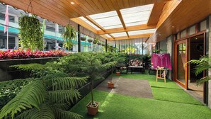 A covered outdoor area with artificial grass, potted plants, and a seating area. - Sumitel Shangrila (Gangtok)